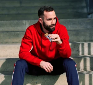 Man eating a protein chocolate bar outdoors