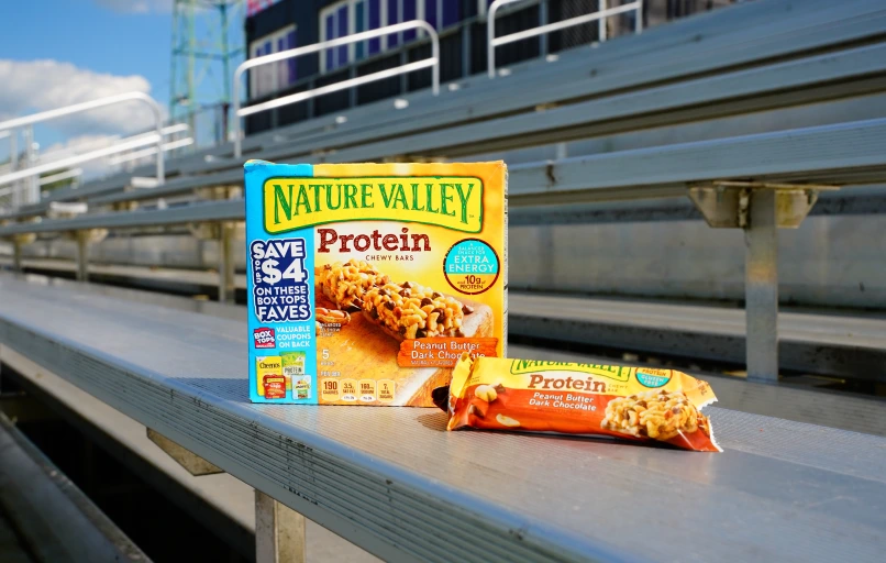 Nature Valley protein granola bar box and snack bar on outdoor bleachers